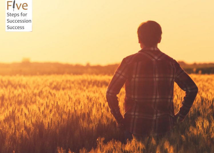 Two farmers talking in wheat field in front of combine harvester
