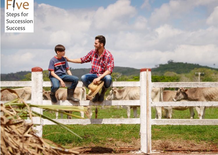 Two farmers talking in wheat field in front of combine harvester